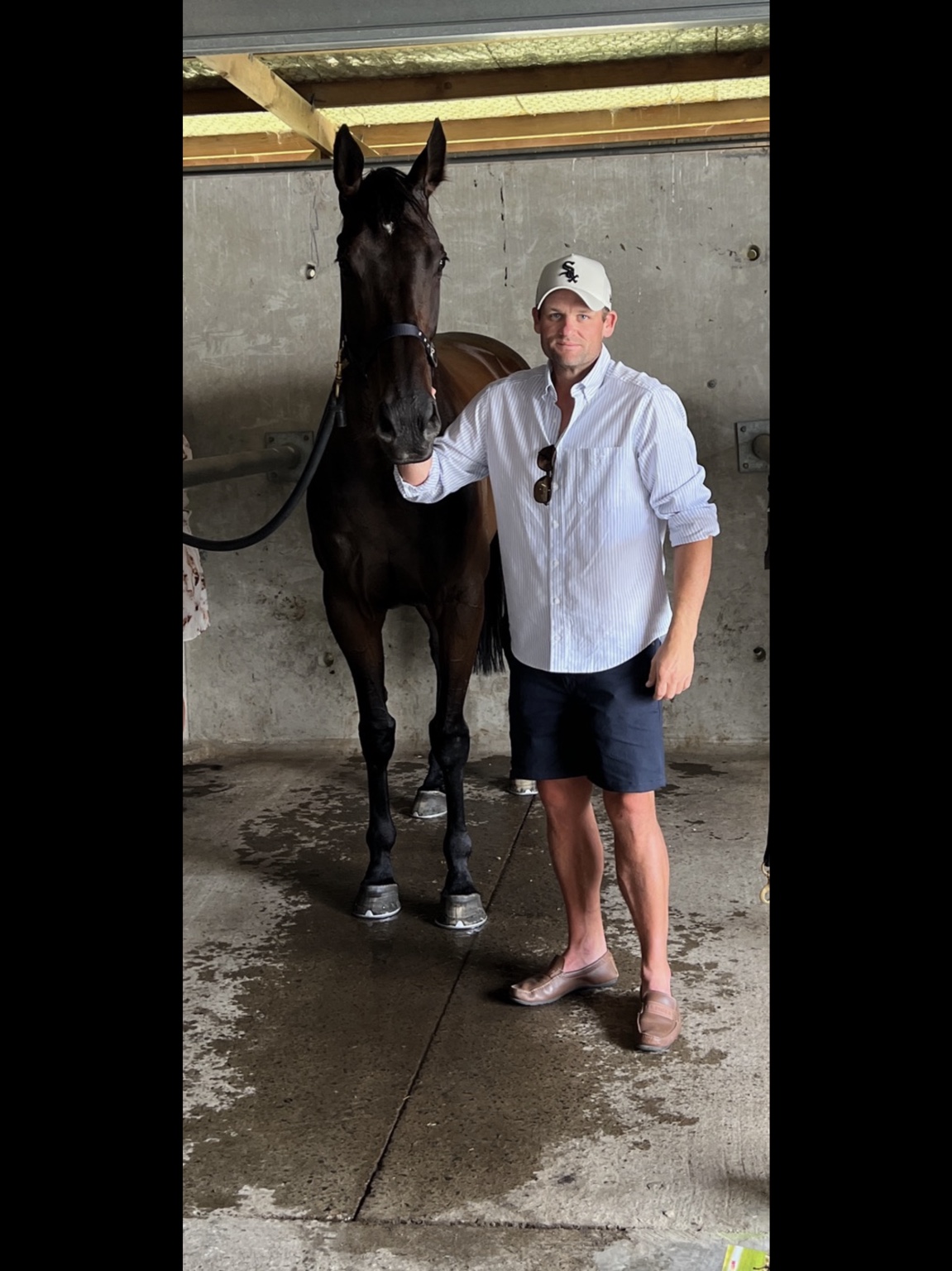Michael Hughes standing beside a thoroughbred